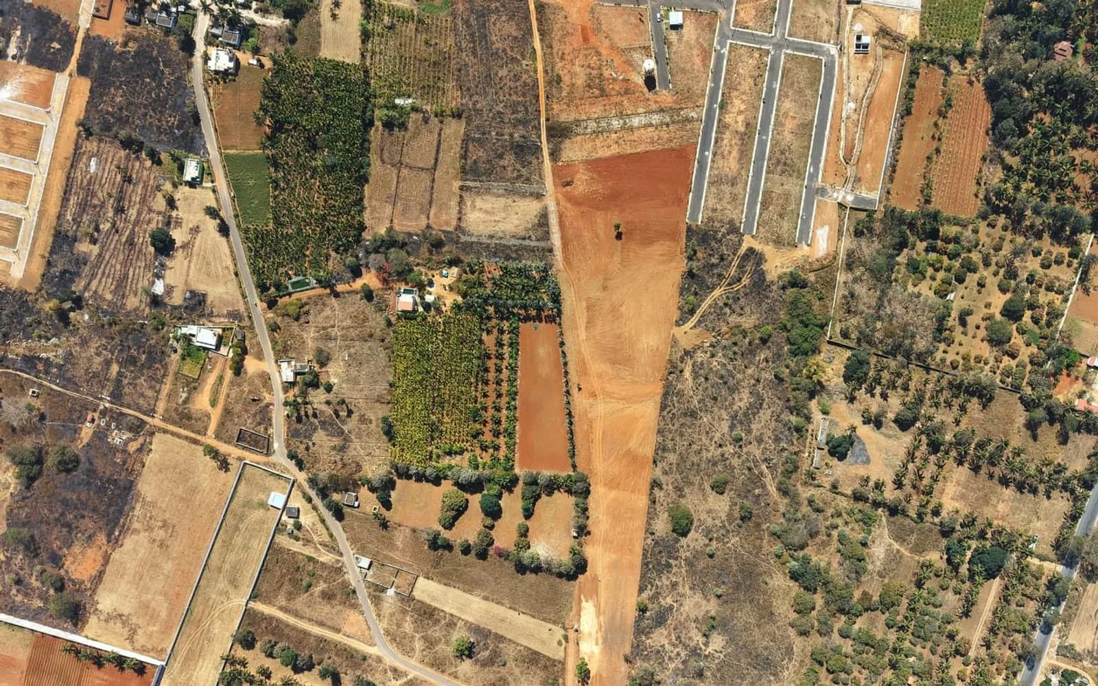 Aerial view of development plots and green land near the city